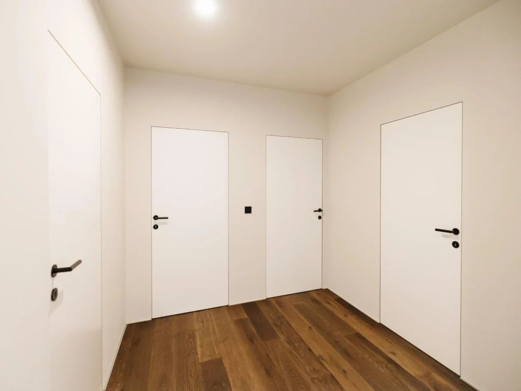 Weiße Tür im Korridor mit dunkelbraunen geölten Parkett